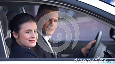 Young couple sitting happily in car after romantic date, loving relationship Stock Photo