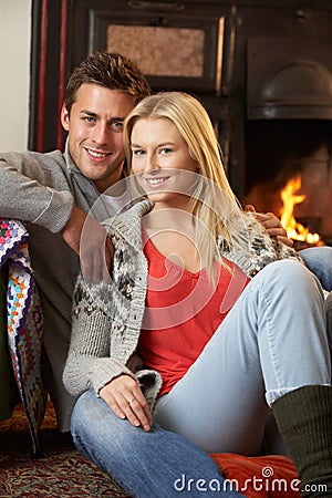 Young couple sitting by open fire Stock Photo