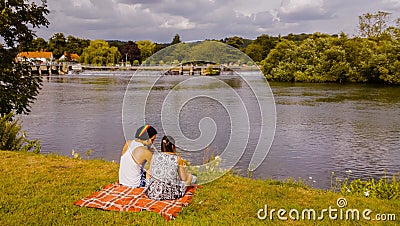 Young Couple Sitting on River Bank Editorial Stock Photo