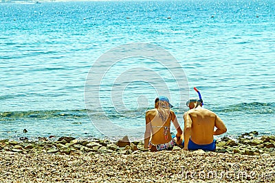 Young couple sitting on the shore of the red sea Editorial Stock Photo