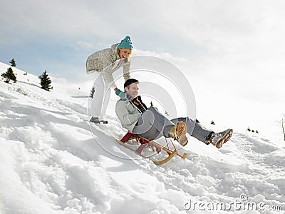 Young Couple Sledding Stock Photo