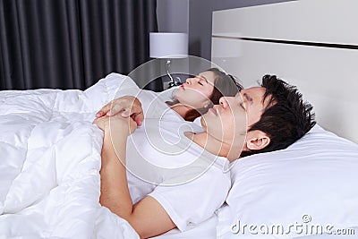 Couple sleeping on a comfortable bed in bedroom at home Stock Photo