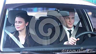 Young couple smiling feeling modest on first date, sitting in car, romance Stock Photo