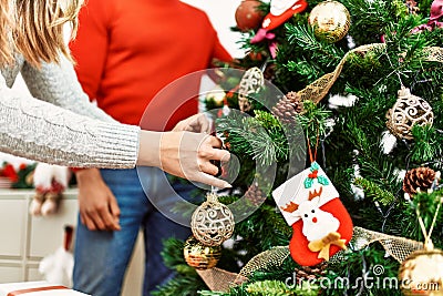 Young couple smiling happy decorating christmas tree at home Stock Photo