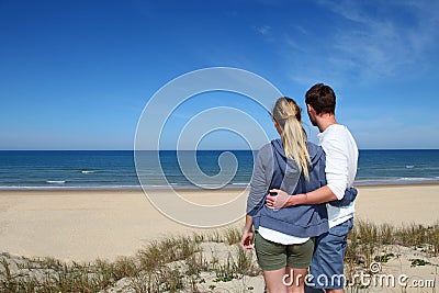 Young couple standing on the beach Stock Photo
