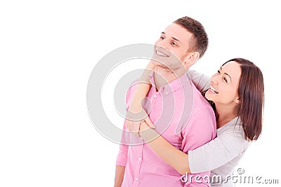 A young couple standing together, hugging and looking at something. Stock Photo