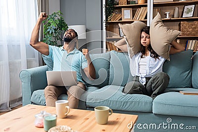 Young couple stares at the ceiling and yells because a neighbor upstairs is having a party with loud music or renovating an Stock Photo