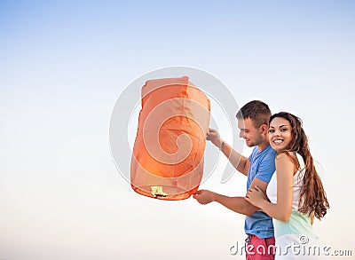 Young couple start a red Chinese sky lantern Stock Photo