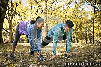 Young couple stretching before running in city park. On the move Stock Photo