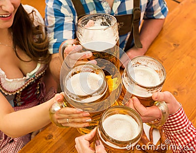 Young couple toasting in Oktoberfest beer tent Stock Photo