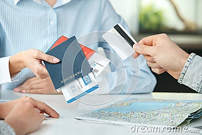 Young couple in a tour agency communication with a travel agent travelling concept credit card payment close-up Stock Photo