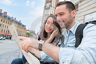 Young couple of tourists booking an activity Stock Photo