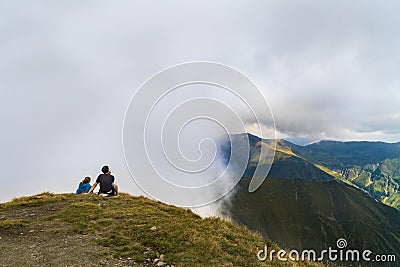 Young couple traveler standing and looking at beautiful landscape on top of mountain Editorial Stock Photo