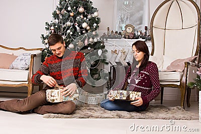 Young couple unwrapping their Christmas gifts Stock Photo