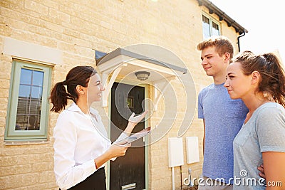 Young couple viewing a house with female real estate agent Stock Photo