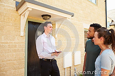 Young couple viewing a house with male real estate agent Stock Photo