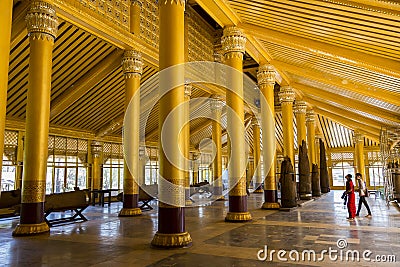 Young couple visiting the impressive interior of Kambawzathardi Golden Palace in Bago Editorial Stock Photo