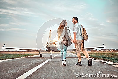 Young couple walking on runway. People carring backpacks Stock Photo