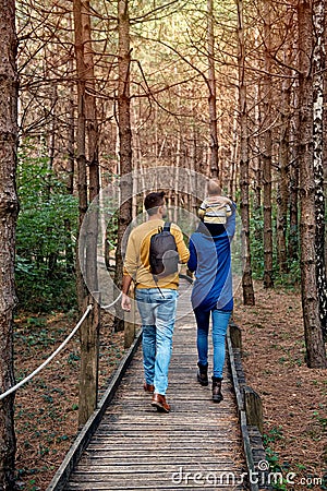 A young couple walks in the woods with a little boy Stock Photo