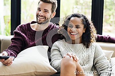 A young Couple watching a tv show together Stock Photo