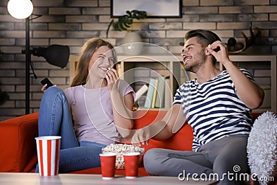 Young couple watching TV on sofa at night Stock Photo