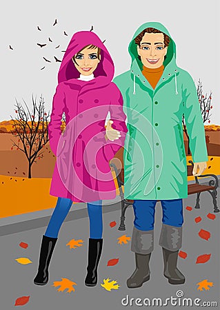 Young couple wearing raincoats standing in park in autumn Vector Illustration