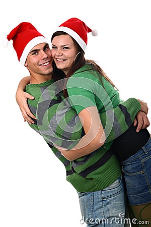 Young couple wearing Santa hats hugging each other Stock Photo
