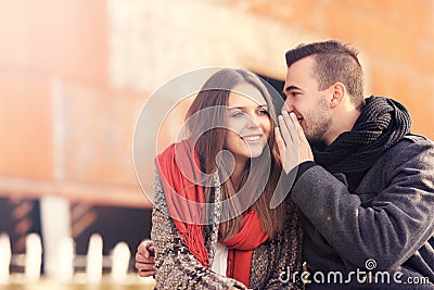 Young couple whispering on an autumn day Stock Photo