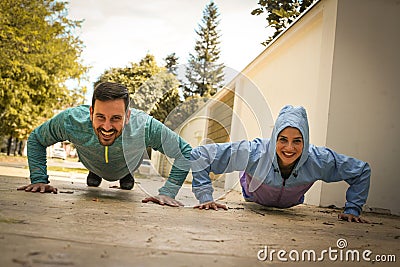 Young couple working pushbuttons on street. Healthy lifestyle. Stock Photo