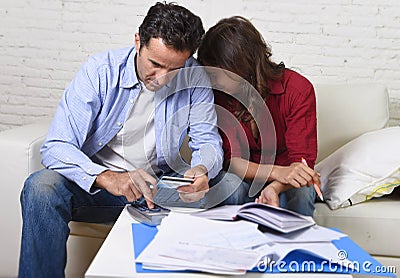 Young couple worried and desperate on money problems at home in stress accounting bank payments Stock Photo