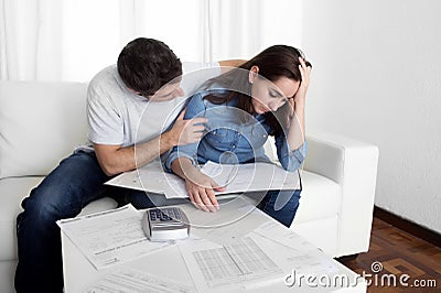 Young couple worried home in stress husband comforting wife in financial problems Stock Photo