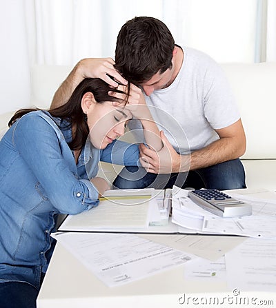 Young couple worried home in stress husband comforting wife in financial problems Stock Photo