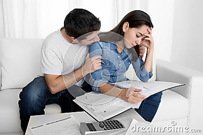 Young couple worried home in stress husband comforting wife in financial problems Stock Photo