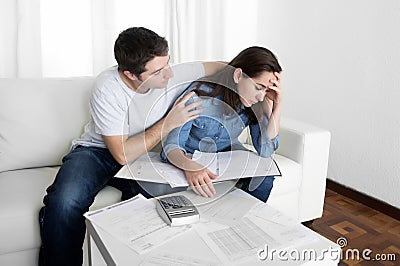 Young couple worried home in stress husband comforting wife in financial problems Stock Photo