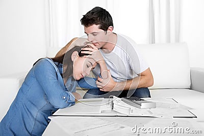 Young couple worried home in stress husband comforting wife in financial problems Stock Photo