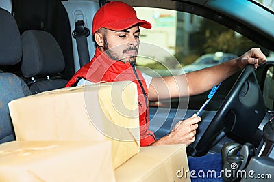 Young courier checking amount of parcels Stock Photo