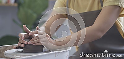 Young craftswoman working on pottery wheel in handmade ceramics workshop. Creative activities, pottery, ceramics art concept Stock Photo