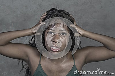 Young crazy desperate and anxious black african American woman feeling stressed and tormented in intense and dramatic face express Stock Photo