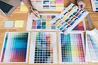 Young creative Graphic designer using graphics tablet to choosing Color swatch samples chart for selection coloring with work too Stock Photo