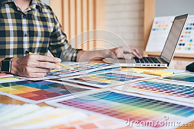 Young creative Graphic designer using graphics tablet to choosing Color swatch samples chart for selection coloring with work too Stock Photo