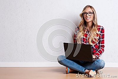 Young creative woman sitting in the floor with laptop./ Casual b Stock Photo