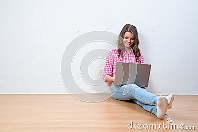 Young creative woman sitting in the floor with laptop Stock Photo