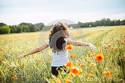 Young woman running through a field of wildflowers Stock Photo
