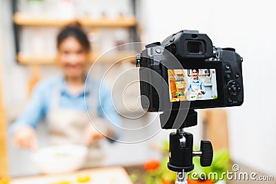 Young cute Asian blogger girl recording video tutorial session of salad cooking lesson at home kitchen. Food blogging concept Stock Photo