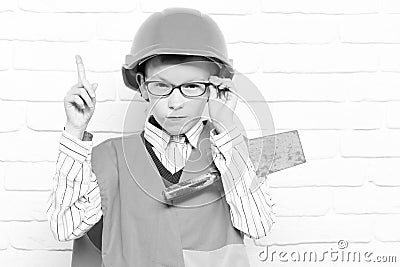 Young cute builder boy on white brick wall background Stock Photo