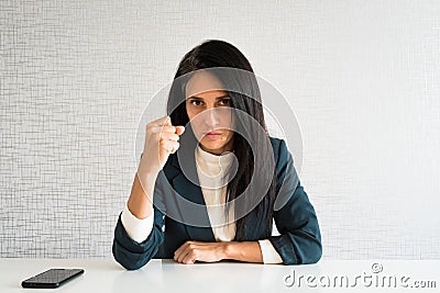 Young cute caucasian brunette business woman director in office show fist to camera at work for employee resentful angry serious Stock Photo