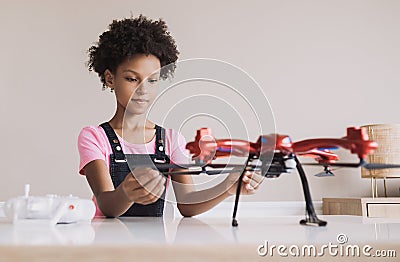 Young cute girl holding quadcopter. Child playing with drone at home. Stock Photo