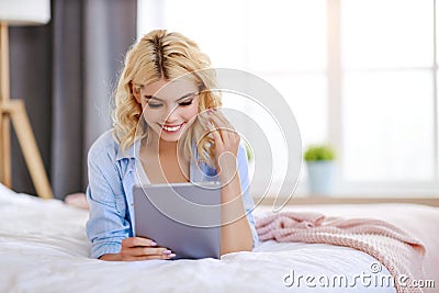 Young cute girl with tablet at home in n bed bedroom Stock Photo