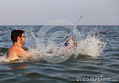 Young dad plays with her daughter and the little girl makes spla Stock Photo