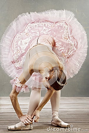 Young dancer fixing her slippers Stock Photo